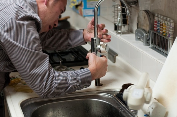 man trying to fix kitchen sink